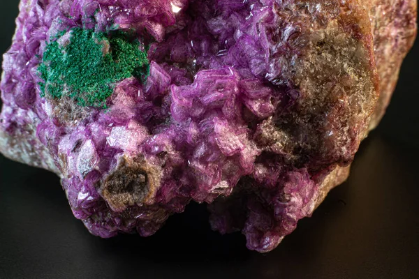 深绿色孔雀石晶体宏观孤立在黑色表面的活泼粉色方解石 — 图库照片