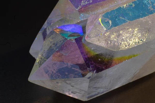 Pastel colourful Angel Aura Quartz crystal point cluster macro isolated on a black surface