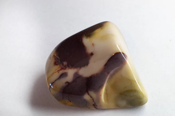 一个棕色和米黄色的莫卡石碧玉的宏观摄影在白色的表面上被剥离 巧克力色水晶 — 图库照片