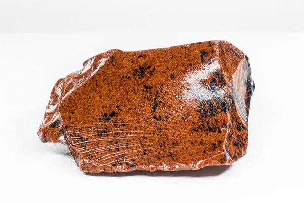 白色皮革背景上孤立的橙色红木奥比西底火山巨石的真正光泽标本 — 图库照片