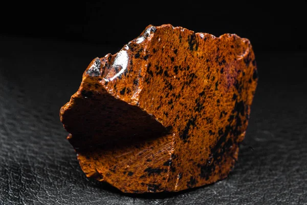 黑皮革背景分离出的橙色红木奥比西底火山巨石的真正光泽标本 — 图库照片