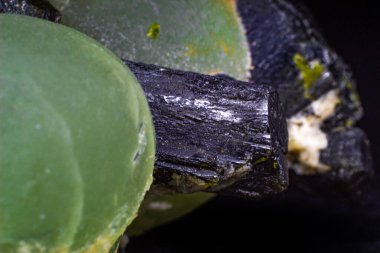 Siyah bir yüzeye izole edilmiş matris makrosundaki gerçek yeşil ve koyu yeşil epidot çıkıntıları. 