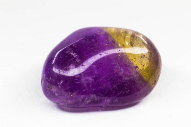 Real tumbled purple and yellow Ametrine crystal stone macro isolated on a white surface. Purple crystal with a bit of yellow colouration on the edge. A crystal combination of purple amethyst and yellow citrine clipart