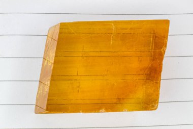 Şeffaf sarı turuncu dikdörtgen optik kalsit kristal İzlanda boks taş makro izole edilmiş çizgilerin nasıl kopyalandığını gösteren bir defter, çift kırılma, çift optik kırılma