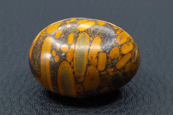 グレー オレンジ色の竹の葉碧玉の玉の玉座は 灰色の革の背景表面に分離された結晶石のマクロをつまずいた — ストック写真
