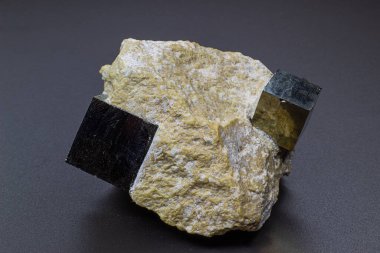 Gri arkaplan yüzeyinde izole edilmiş beyaz matris makrosu üzerindeki makro gri mükemmel kübik pirit metali  