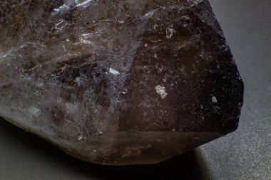 Makro gri kahverengi dumanlı kuvars. Siyah yüzey arka planında izole edilmiş doğal nokta makro.