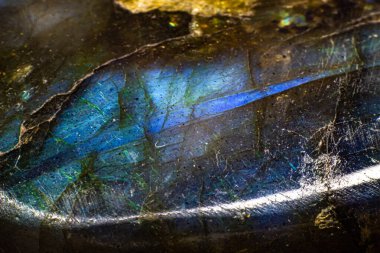 Beyaz arka plan yüzeyinde tamamen izole edilmiş parlak mavi labradorit makro. Sarı benekli mavi taş