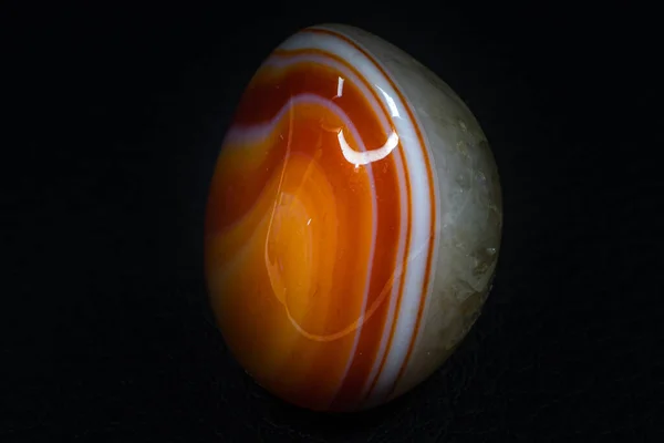 黒色の背景表面に透明な石英が集中して孤立したオレンジ色の方解石の瑪瑙の玉髄のマクロ写真 バンド瑪瑙の壁紙興味深いライン — ストック写真