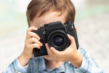 Fotoğrafçı çocuk kamerayla fotoğraf çekiyor.