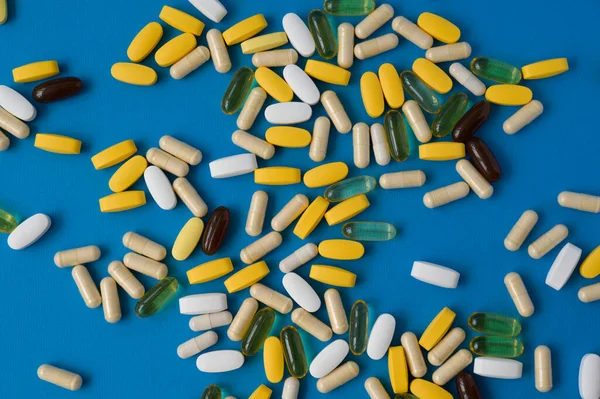 Vista dall'alto di molte pillole compresse gel e capsule di medicina farmacia sulla superficie blu Fotografia Stock