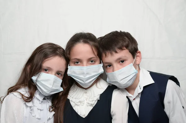 Familia a trei copii mici în măști medicale și uniformă școlară în timpul epidemiei de carantină COVID-19 cu spațiu de copiere fotografii de stoc fără drepturi de autor