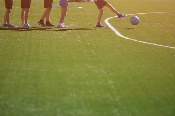 Football and soccer shcool training group of kids kicking ball on green field playing sport game with copy space — Zdjęcie stockowe