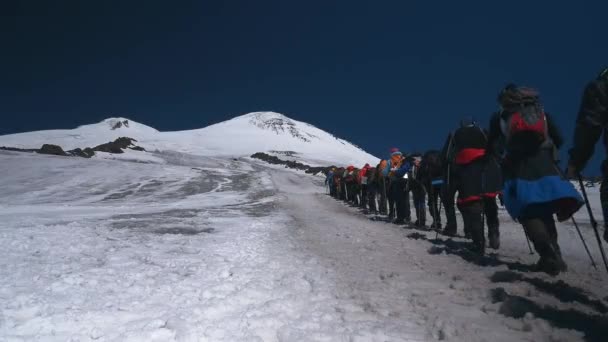 Muchas personas deportivas con equipos de escalada que se elevan en alta montaña durante la actividad de ocio al aire libre pico de tierras altas de nieve con espacio de copia — Vídeo de stock