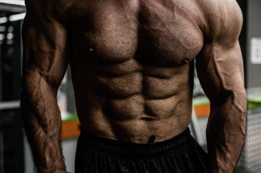 Kaslı fizikli, güçlü, genç ve kaslı bir erkek sporcu.