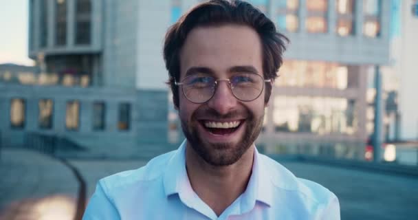 カメラを探して笑顔のCEOエグゼクティブの肖像。30代男性実業家古典的なスーツを着て屋外で現代的なオフィスビルの背景にポーズ. — ストック動画