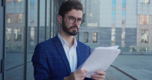 Homme d'affaires portraitiste regardant des papiers. Homme debout avec des documents à l'extérieur . — Video