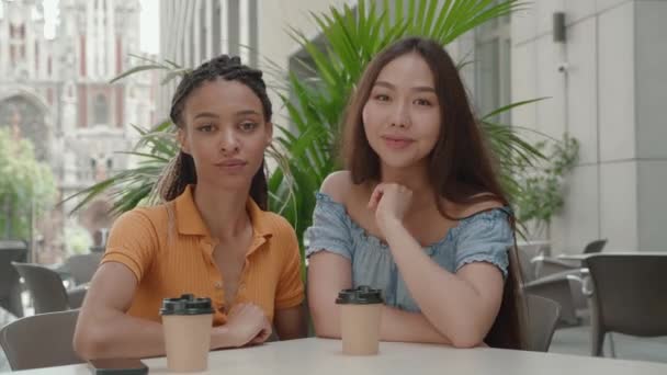 Duas namoradas felizes sorridentes mulher vlogger falando olhando para a câmera sentada no café — Vídeo de Stock