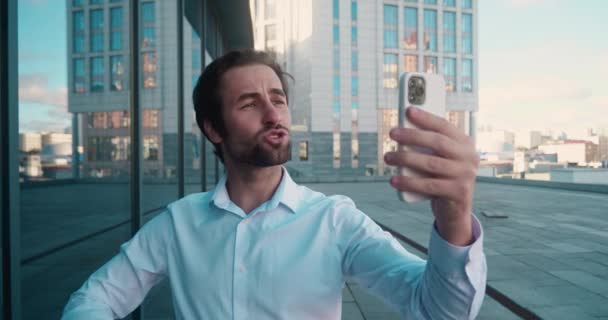 Empresario que tiene video chat en el teléfono inteligente. Empleado masculino usando teléfono en la calle . — Vídeos de Stock