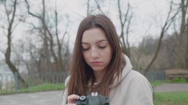 Mutlu esmer kadın güzel bir parkta, boş zamanlarında ve ön manzarada fotoğraf çekiyor.