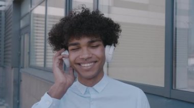 Modern Afro-Amerikan portresi, açık havada kulaklıkları olan çekici, çekici, genç bir adam.