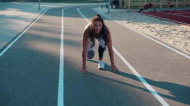 Pistteki bayan sporcu. Genç bir kadın stadyumda başlıyor, sonra yarışmaya hazırlanıyor..