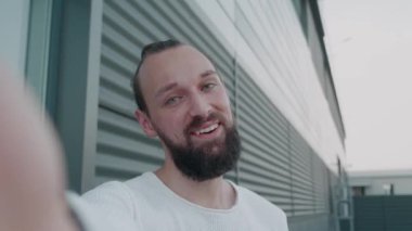 Sokakta dikilirken arkadaşlarla ya da iş arkadaşlarıyla konuşan, güzel, genç ve şık bir adamın portresi. El sallayan el ofis binasının yanında..