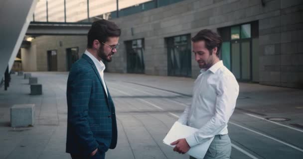 屋外に立つビジネスパートナーとの成功した会議を議論する陽気な男性の同僚. — ストック動画