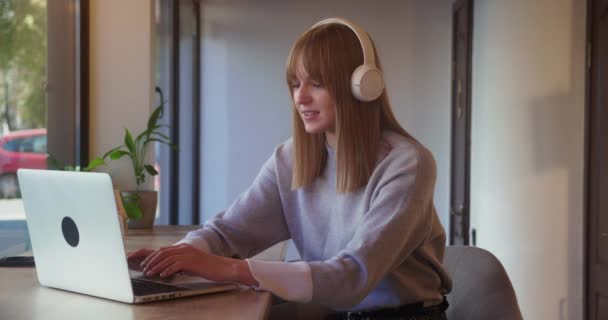 Γυναίκα νεαρός εργαζόμενος χρησιμοποιώντας φορητό υπολογιστή στο χώρο εργασίας ή καφέ και το πόσιμο τσάι. Μελέτη, εργασία, απομακρυσμένη εργασία, έννοια freelance — Αρχείο Βίντεο