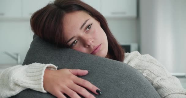 Worried Senior woman. Tred girl hugged the pillow with her hands and bowed her head — Stock Video