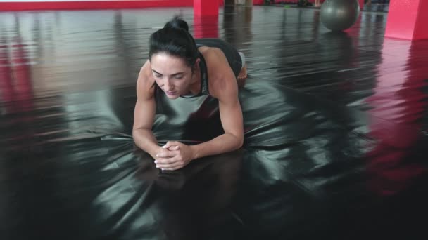 Entrenamiento de estiramiento. Mujer joven haciendo ejercicio en la alfombra de fitness en el gimnasio. — Vídeo de stock