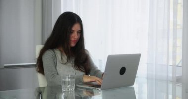 Ofiste bilgisayarla çalışan, müşterilerle iletişim kuran genç bir kadın. Odaklanmış başarılı esmer kadın uluslararası şirket çalışanı proje ile meşgul.