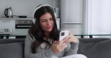 Esmer kadın rahat koltukta oturmuş kulaklıkla müzik dinliyor. Rahat konsept, boş zaman veya boş zaman