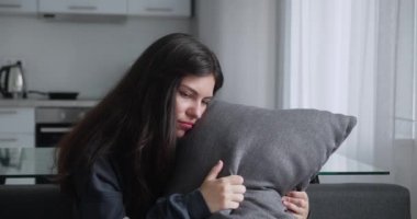 Üzücü düşüncelere dalmış Hint etnik kökenli kadın yastığa sarılıyor yalnız başına düşünüyor hayal kırıklığına uğramış ve üzgün hissediyor kişisel hayat sorunları, boşanma ve ayrılık evliliği.