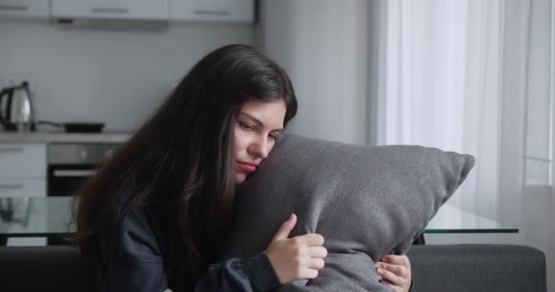 Lost deeply in sad thoughts indian ethnicity mixed race woman hugs the pillow sitting on couch alone thinking feels frustrated and upset, personal life troubles, divorce and break up marriage split — Stock Video