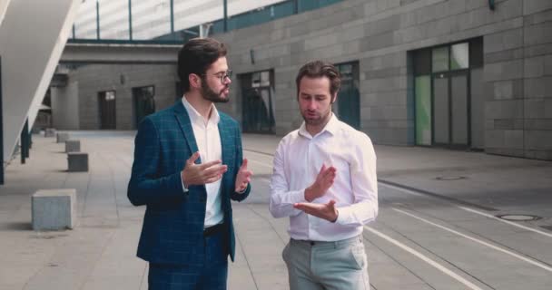 将来のプロジェクトのための共同計画を議論する都市の通りに立っている2人の成功したビジネスマン。都市ビジネスライフスタイルコンセプト — ストック動画