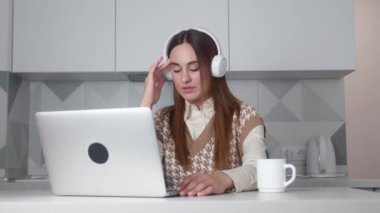 Modern bir ofiste kulaklık ve bilgisayar kullanan genç bir kadının 4K video görüntüleri.