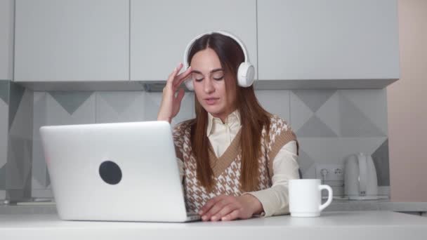 4k videofilmer av en ung kvinna som använder ett headset och en dator på ett modernt kontor — Stockvideo