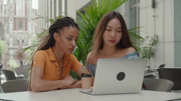 가을 학기에 대학생들의 모습. 두 명의 학생 파트너가 노트북을 만들고 있다. 좋은 소식을 읽고 우승을 축하하는 것. 아시아 소녀들 과 아프리카 계 미국인 — 비디오