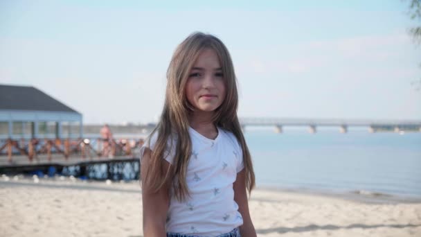 Portret dziewczynki 9 lat patrząc w kamerę i uśmiechnięte tło piękne niebo i morze — Wideo stockowe