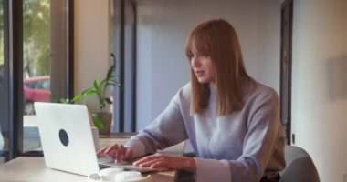 Laptop kullanan çekici genç kız öğrenci. Sörf haberleri okumak, kafede oturup mesaj yazmak.