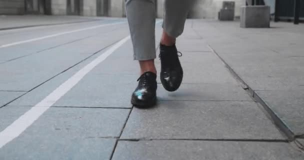 Hombre de negocios pies en zapatos caros caminando sobre placas de hormigón — Vídeo de stock