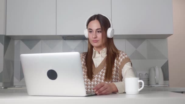Mooie vrouw in hoofdtelefoon met videogesprek met behulp van laptop. — Stockvideo