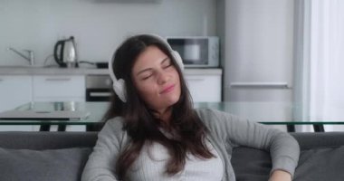 Kanepe arkasında müzik dinleyen genç bir kız.
