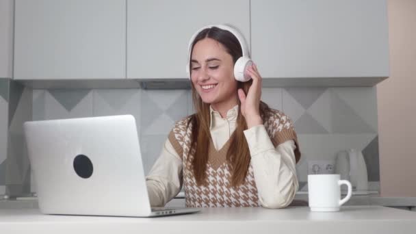 Joven mujer de negocios con auriculares comunicándose por videollamada. — Vídeos de Stock