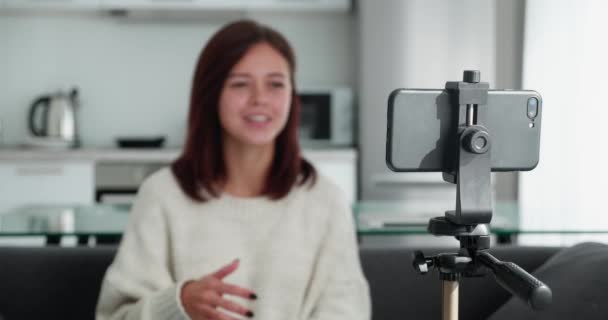 閉じるアップの女性ブロガー撮影ビデオとともにスマートフォンオン三脚 — ストック動画