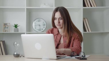PC 'nin masasında oturan üzgün genç bir kadın, hayal kırıklığına uğramış ve endişeli bir serbest kadın, elleriyle başını tutuyor, sorunları ve zorlukları var, bilgisayar hatası, işte bir hata yaptı..