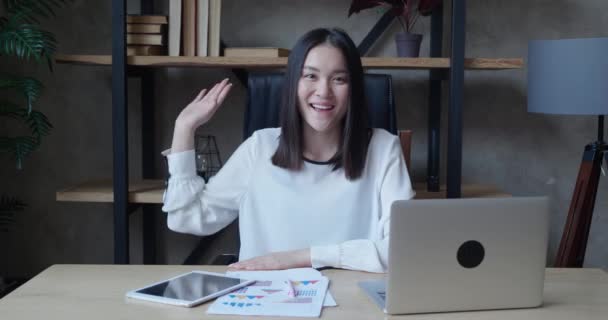 Konsultacje online i koncepcja prezentacji zdalnej. Azjatycka kelnerka patrzy w kamerę, wyjaśnia coś swojemu rozmówcy i gestom rękami. Zamknij drzwi. Nadaje. — Wideo stockowe