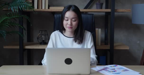 アジアのビジネス女性は彼女のテーブルで働き始めます彼女は現代のオフィスでラップトップを開きます.ビジネスと金融の概念. — ストック動画