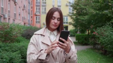 Kız telefona bakar ve renkli binaların arka planında gördüklerine şaşırır. Yavaş çekim